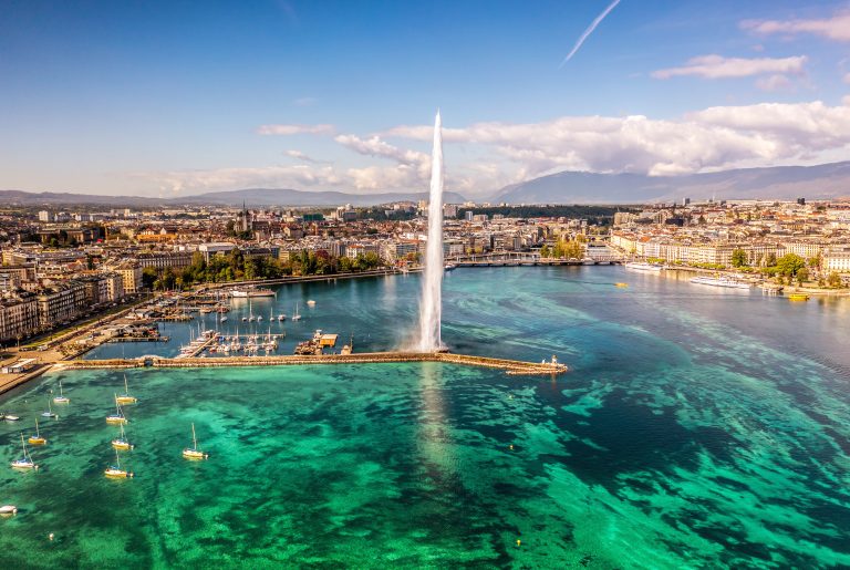 Scenic aerial view of Geneva's water fountain with boats in the foreground Image description